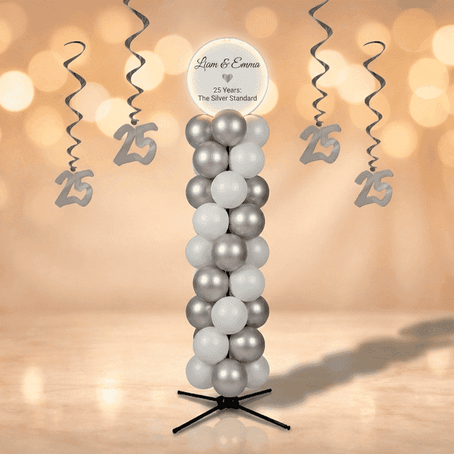 Zilver-witte ballonpilaar met rond wit topbord met jubileumnamen, staand in een champagne-gouden feestzaal met kristallen kroonluchters