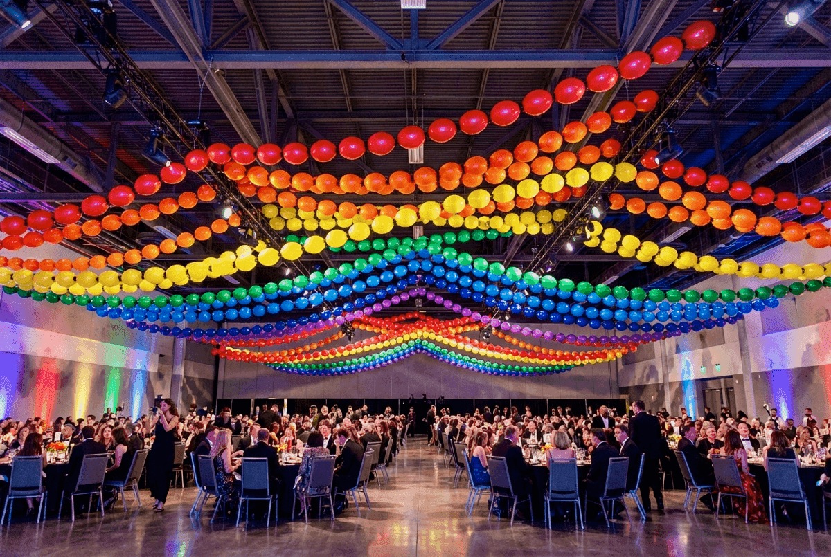 Lange regenboog ballonslinger boven festivalterrein