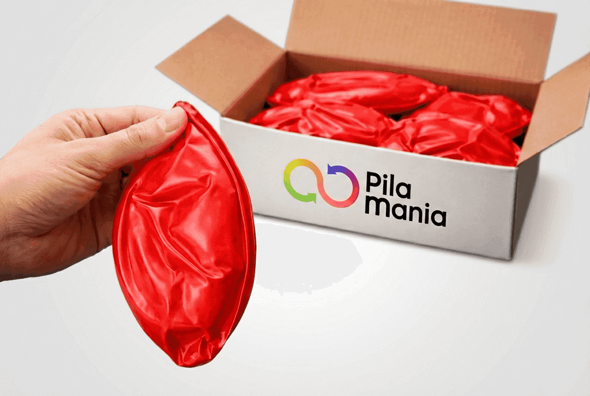 Hand houdt een lege PVC bal vast boven een doos met meerdere platte ballen