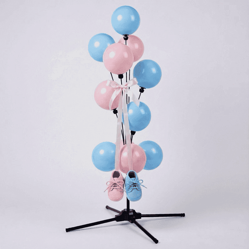 Lieve gender reveal ballonfontein met roze en blauwe babyschoentjes hangend aan gouden linten tussen de ballonnen