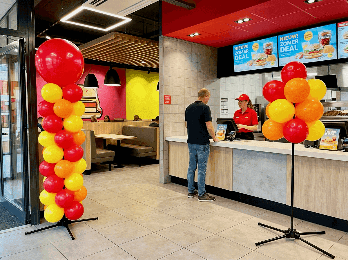 Quick service restaurant met rode en gele ballondecoratie bij actiepromotie